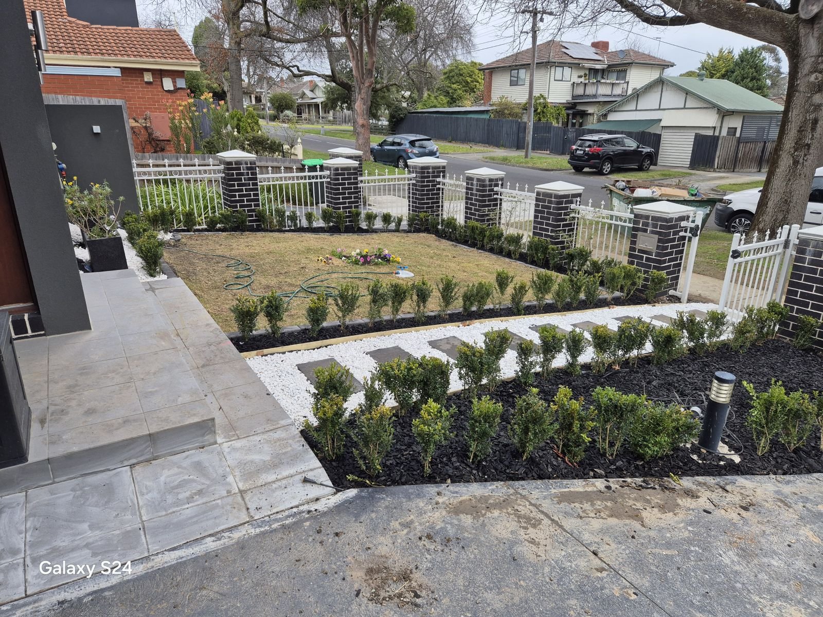 New townhouse front garden with hedges, white pebbles, stepping stones and lighting